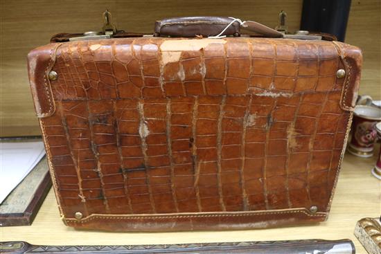 An early 20th century crocodile skin briefcase and a suitcase length 49cm